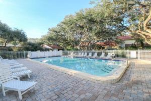 圣奥古斯丁St Augustine Beach & Tennis Resort 1002的一个带椅子和白色围栏的游泳池