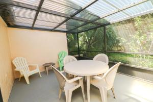 圣奥古斯丁St Augustine Beach & Tennis Resort 1002的一间有桌子、椅子和窗户的房间