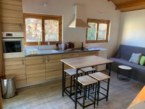 a kitchen and living room with a table and a couch at Villa et chalet avec piscine proche Aix & Luberon in Peyrolles-en-Provence