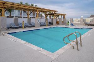 a swimming pool at a hotel with chairs and a pavilion at Hampton Inn and Suites Port Aransas in Port Aransas