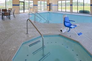 a large swimming pool with a blue chair in a building at Hampton Inn Carbondale in Carbondale