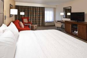 una camera d'albergo con un grande letto bianco e una scrivania di Hampton Inn Carbondale a Carbondale