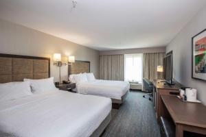 シンシナティにあるHampton Inn & Suites - Cincinnati/Kenwood, OHのベッド2台とテレビが備わるホテルルームです。