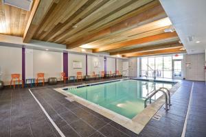 a pool in a large room with a large wooden ceiling at Home2 Suites By Hilton Blue Ash Cincinnati in Blue Ash