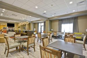 un comedor con mesas y sillas y una cafetería en Hampton Inn Blue Ash/Cincinnati, OH, en Blue Ash