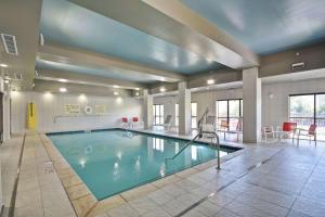 a large swimming pool in a building with a table and chairs at Hampton Inn Blue Ash/Cincinnati, OH in Blue Ash
