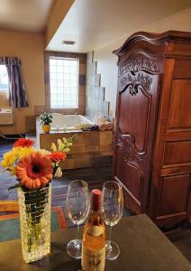 Rundle Mountain Lodge في كانمور: غرفة بها كأسين وزجاجة من النبيذ
