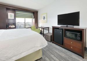 a hotel room with a bed and a flat screen tv at Hampton Inn Los Angeles/Carson in Carson