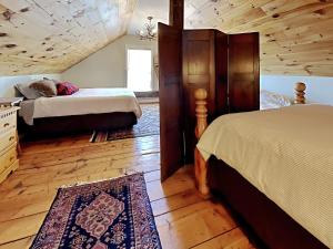 1 dormitorio con 2 camas y techo de madera en The 1827 House, en West Dover