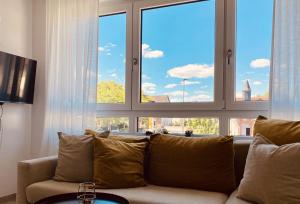 a living room with a couch and large windows at Kapellenblick Seligenstadt in Seligenstadt