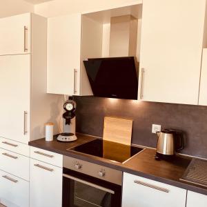 uma cozinha com armários brancos e um forno com placa de fogão em Kapellenblick Seligenstadt em Seligenstadt