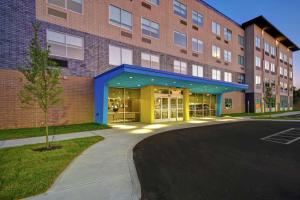 a large brick building with a blue and yellow facade at Tru By Hilton Cincinnati Airport South Florence in Florence