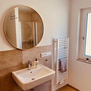 een badkamer met een wastafel en een spiegel bij Kapellenblick Seligenstadt in Seligenstadt