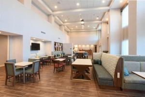 a waiting room with tables and couches and chairs at Hampton Inn & Suites Cincinnati Liberty Township in West Chester
