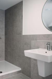 a bathroom with a sink and a mirror and a tub at BRACKEN COTTAGE, The Lanes Cottages, Stokesley in Stokesley