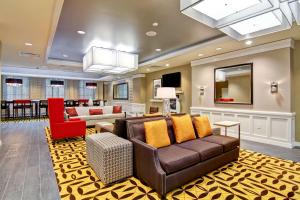 a living room with a couch and a mirror at Hampton Inn and Suites Cincinnati - Downtown in Cincinnati