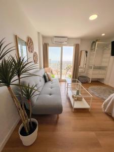 een woonkamer met een bank en een potplant bij Cozy Studio with Sea Views in Benalmádena