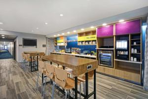 a restaurant with a bar with tables and chairs at Home2 Suites By Hilton Springdale Cincinnati in Springdale