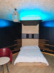 Schlafzimmer mit einem Bett und einem Kronleuchter in der Unterkunft suite tylie avec baignoire balneo type SPA 