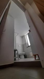 ein Bad mit einem WC und eine Treppe mit einem Fenster in der Unterkunft Galleria 38 in Soverato Marina