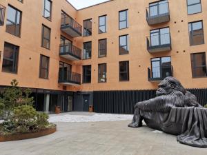 una estatua de un hombre sentado frente a un edificio en MyCasa Paupys, en Vilna