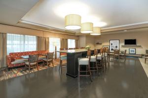 eine Lobby mit einer Bar und Stühlen sowie einem Wohnzimmer in der Unterkunft Hampton Inn Corydon in Corydon