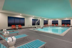 夏安的住宿－Tru By Hilton Cheyenne，一座带椅子和桌子的酒店游泳池