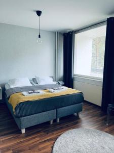 um quarto com uma cama e uma grande janela em Compact apartment in Rauma em Rauma