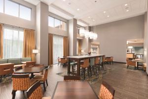 un comedor con mesas, sillas y ventanas en Hampton Inn & Suites - DeLand, en De Land