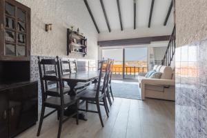 a dining room with a table and chairs and a couch at T3 Praia do Baleal in Ferrel