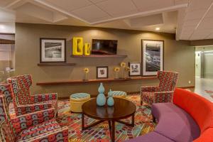 a lobby with chairs and a table and a tv at Hampton Inn Daytona Speedway-Airport in Daytona Beach