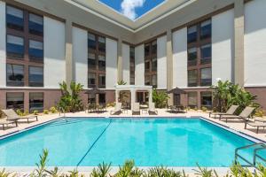 a swimming pool in front of a building at Hampton Inn Daytona Speedway-Airport in Daytona Beach