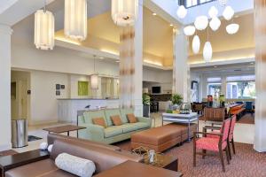 um grande átrio com sofás, cadeiras e mesas em Hilton Garden Inn Addison em Addison