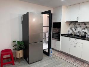 uma cozinha com um frigorífico e um banco vermelho em Casa Mar e Sol - Murdeira - Ilha do Sal em Palha Verde