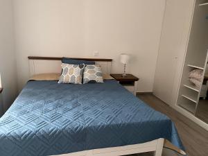 um quarto com uma cama com um edredão e almofadas azuis em Casa Mar e Sol - Murdeira - Ilha do Sal em Palha Verde