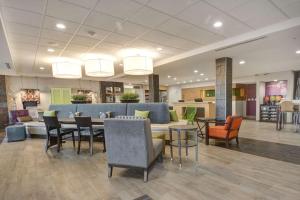 een lobby van een ziekenhuis met een tafel en stoelen bij Home2 Suites by Hilton Irving/DFW Airport North in Irving