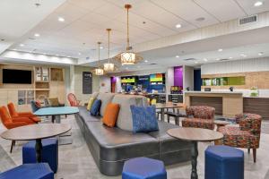 a lobby with a couch and some tables and chairs at Home2 Suites By Hilton McKinney in McKinney