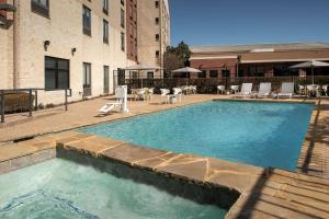 a large swimming pool with chairs and a building at Hilton Garden Inn Dallas/Duncanville in Duncanville