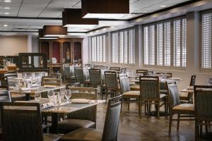 a dining room with tables and chairs and windows at DoubleTree by Hilton Dallas Market Center in Dallas