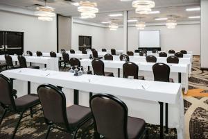 una sala de conferencias con mesas y sillas blancas y una pizarra en DoubleTree by Hilton Dallas Market Center, en Dallas