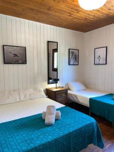 a bedroom with two beds with blue sheets at WAVEShouseTARIFA in Tarifa
