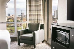 a living room with a chair in front of a window at DoubleTree by Hilton Dallas Market Center in Dallas