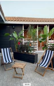 twee stoelen en een tafel op een patio met planten bij WAVEShouseTARIFA in Tarifa