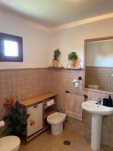 a bathroom with a sink and a toilet and a mirror at WAVEShouseTARIFA in Tarifa