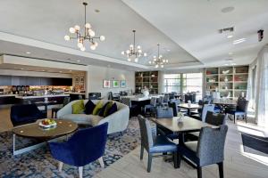 Homewood Suites by Hilton Plano-Richardson في بلانو: لوبي الفندق مع طاولات وكراسي ومطعم