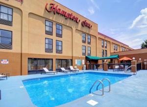 a hotel with a swimming pool in front of a building at Hampton Inn Eden in Eden