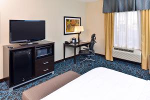 a hotel room with a flat screen tv and a bed at Hampton Inn by Hilton Dayton South in Miamisburg