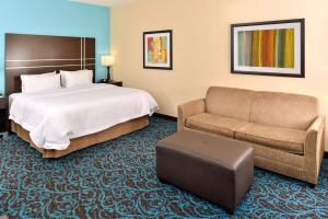 Habitación de hotel con cama y sofá en Hampton Inn by Hilton Dayton South, en Miamisburg