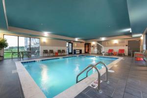 a pool in a hotel with tables and chairs at Hampton Inn & Suites Xenia Dayton in Xenia