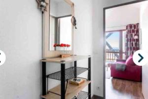 - un salon avec un miroir et une table dans l'établissement Penthouse T2 Valmeinier 1900 skis aux pieds, à Valmeinier 5 autres photos